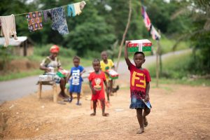 child with shoebox on head